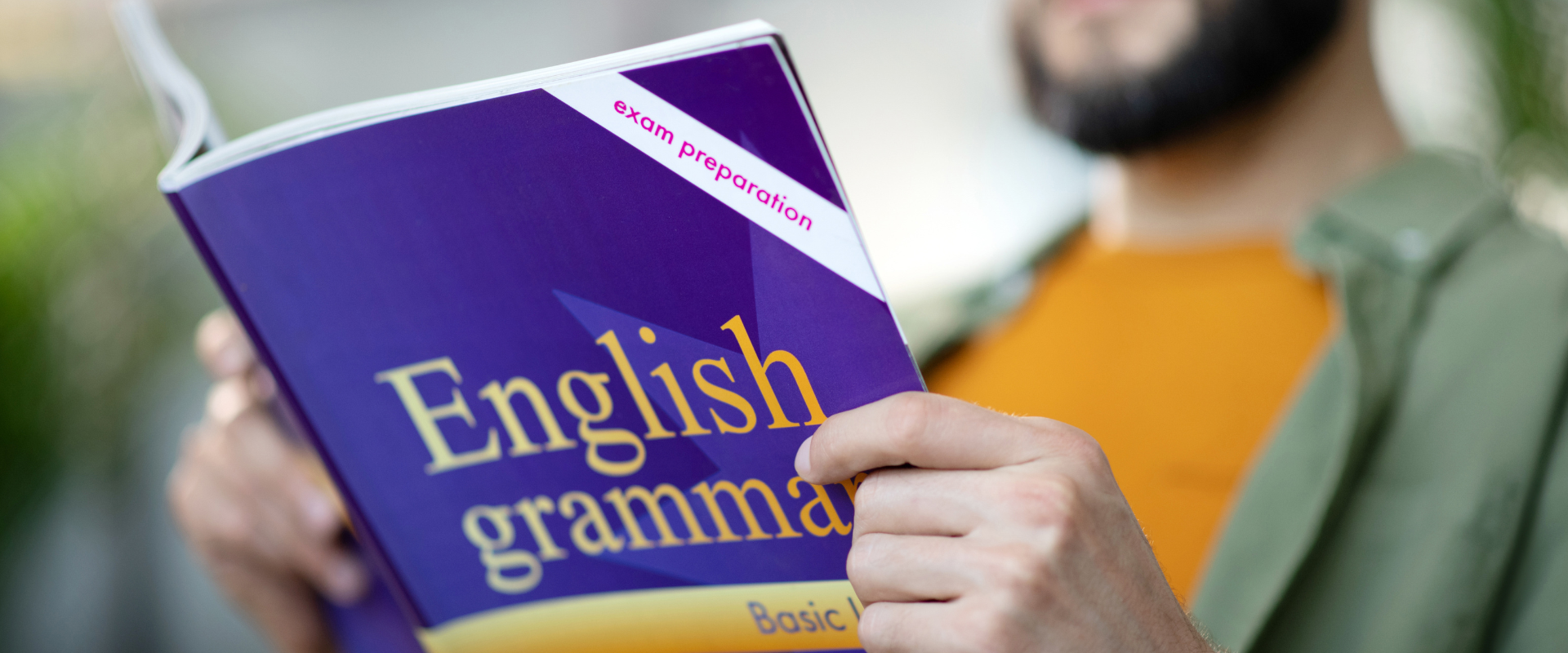 Mężczyzna czytający podręcznik do gramatyki angielskiej