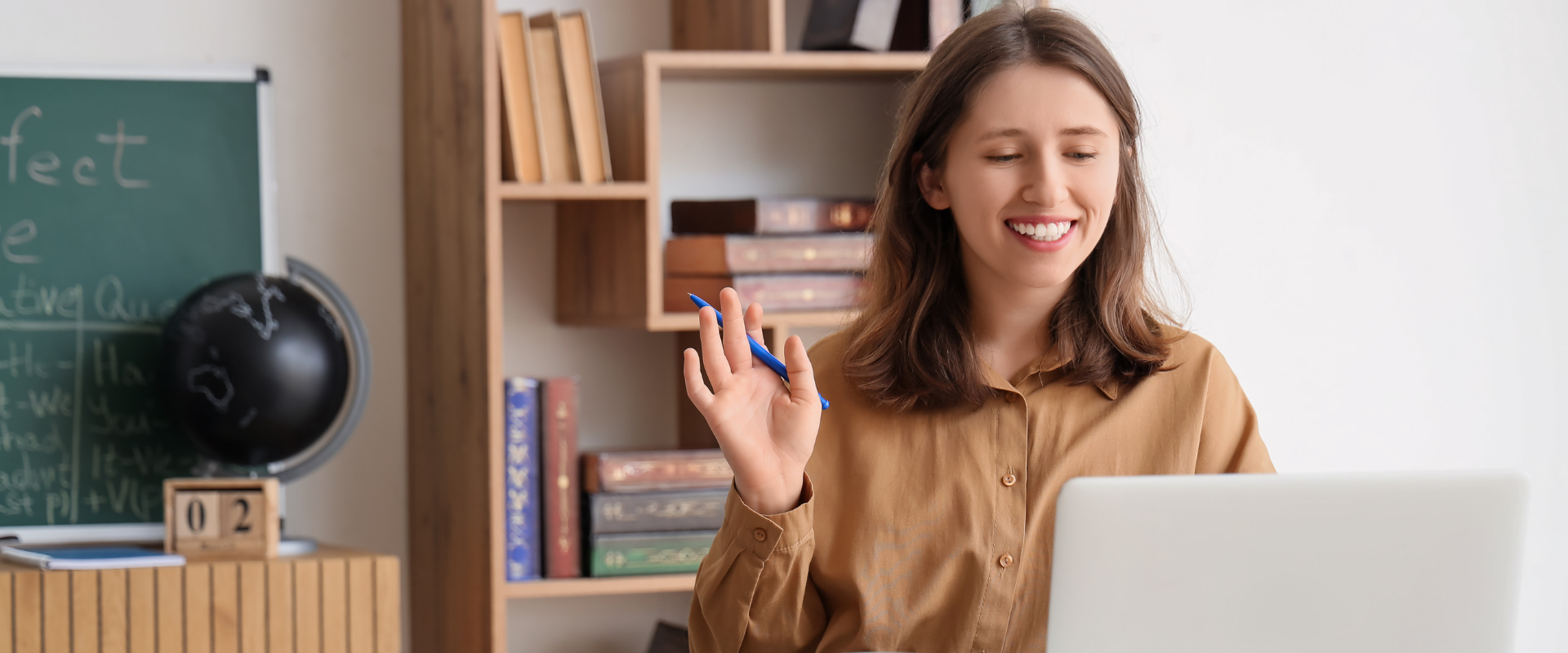 Uśmiechnięta lektorka prowadzi lekcję angielskiego online przy laptopie